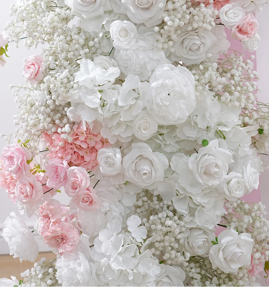 Floral arrangement with white, pink, and baby's breath flowers on a light background