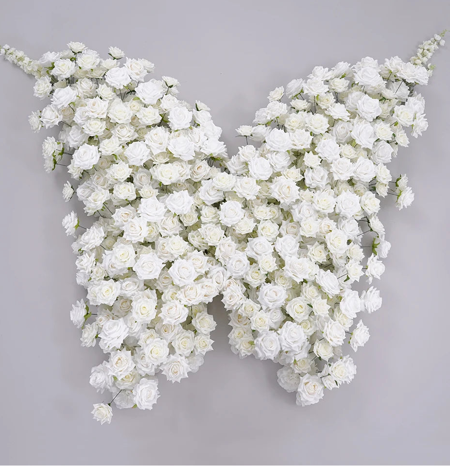 Butterfly-shaped arrangement of white flowers on a gray background