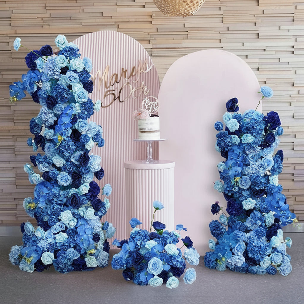 Transform your wedding venue into an elegant focal point with this luxury royal blue backdrop floral arrangement. Expertly crafted with premium blooms in rich sapphire tones, this statement piece combines sophistication with dramatic visual impact. Perfect for ceremonies, receptions, or photo opportunities, the arrangement features layered florals that create depth and dimension against any backdrop. Each stem is carefully selected and arranged to ensure lasting beauty throughout your celebration. An invest