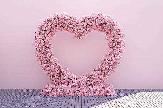 Heart-shaped arrangement of pink flowers on a white background with Weddingstoryshop 